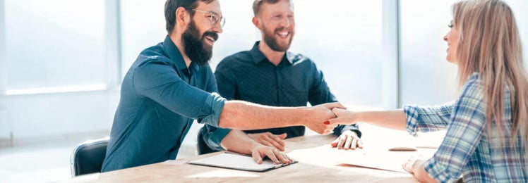 man and woman shaking hands at table
