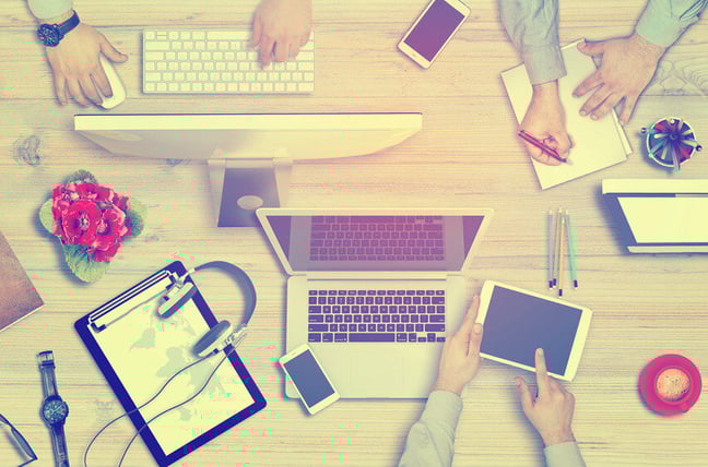 people working on computer desktop and notepad